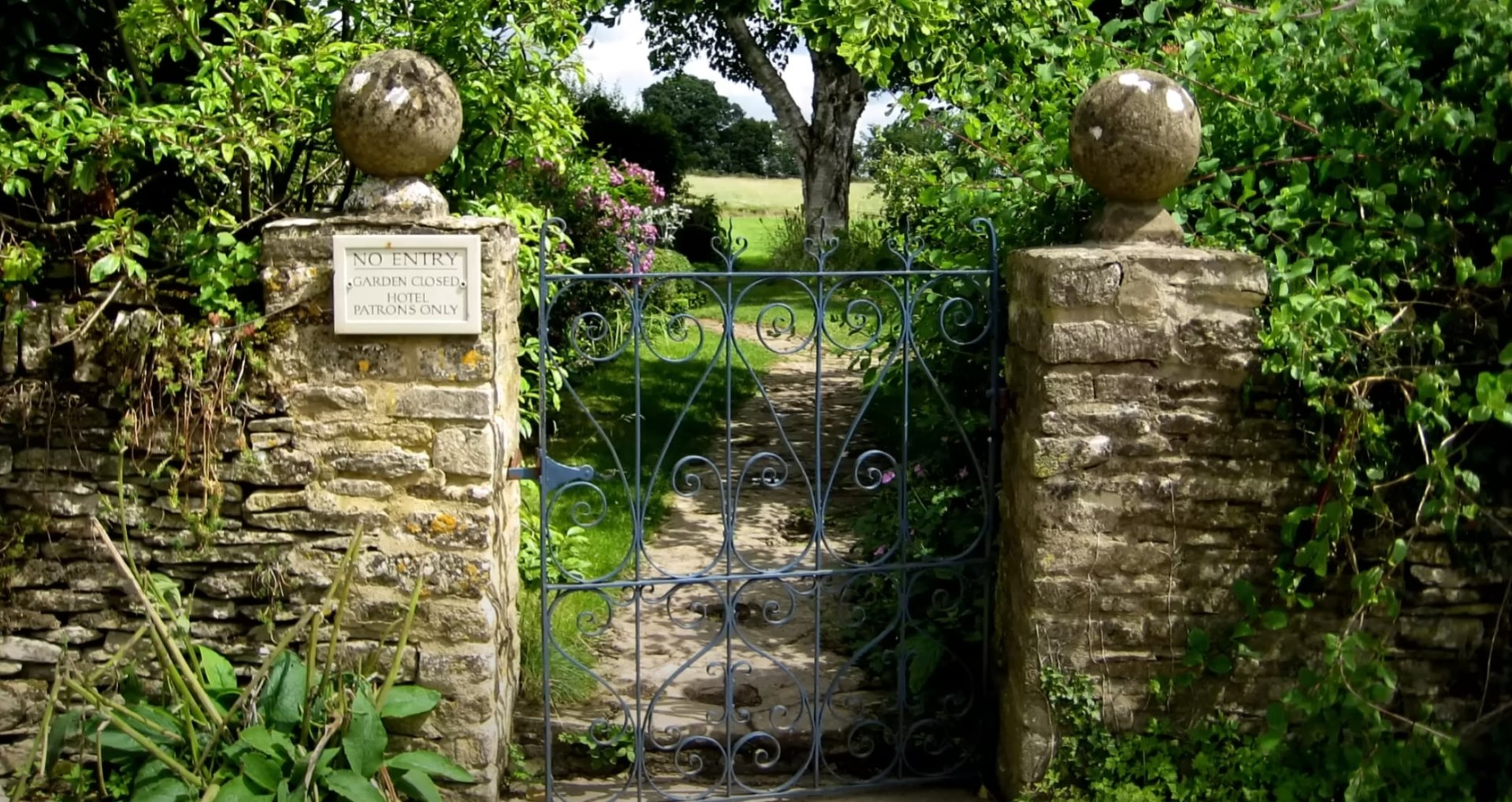 Historic Garden Restoration with Iron Gates and Stone Architecture Historic garden entrance with ornate iron gates, stone pillars, and vintage landscaping design elements
