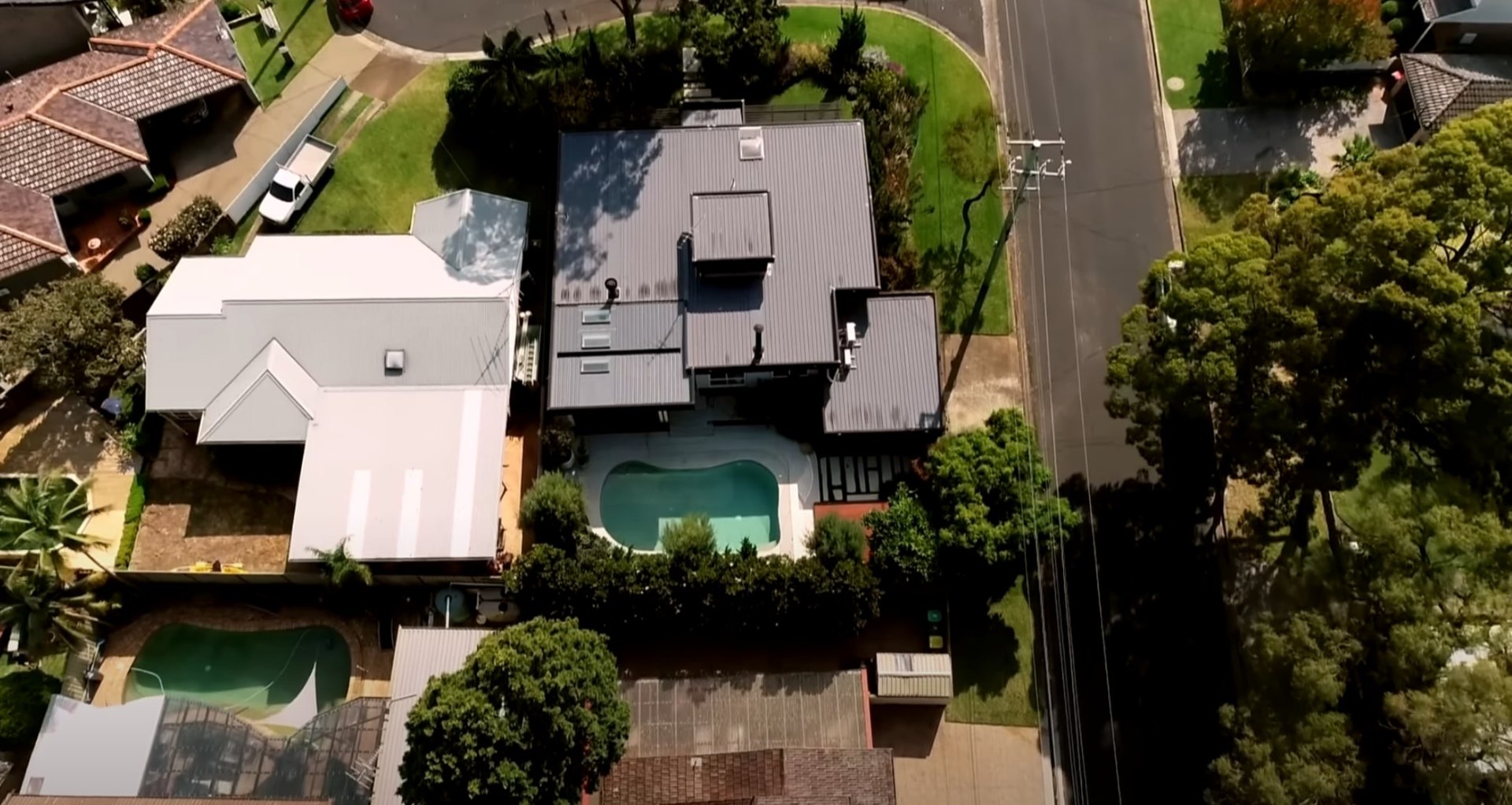 Complete Property Landscaping - Aerial View of Lawn Care and Pool Area Aerial view of residential property showing professional lawn care, swimming pool, and comprehensive landscape maintenance